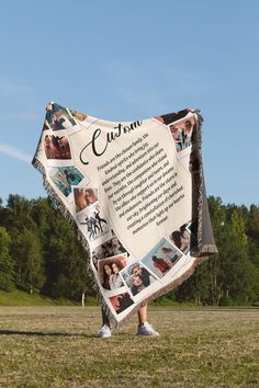 a woman standing in the grass holding a blanket with photos on it that says custom