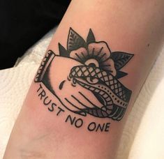 a black and white photo of a tattoo that says trust no one