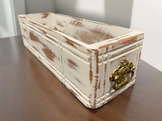 a wooden box sitting on top of a table next to a white wall and door