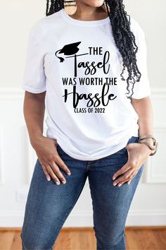 a woman wearing a white t - shirt that says the tassel was worth the rose class of 1932