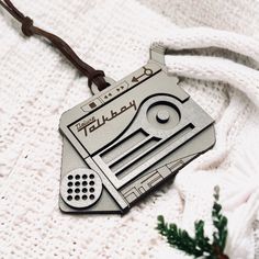 an ornament shaped like a radio cassette player on a white sweater with a brown cord