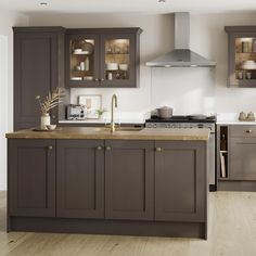 a kitchen with gray cabinets and wooden floors