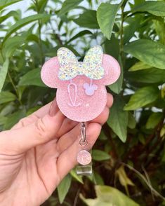 a hand holding a pink minnie mouse keychain