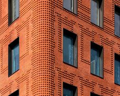 an orange brick building with several windows on the front and side, all made out of red bricks