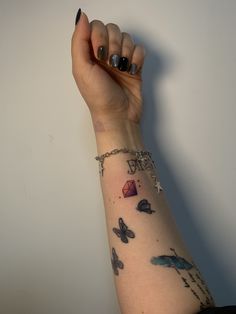 a woman's arm with tattoos on it and a chain attached to the wrist