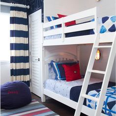 two bunk beds in a bedroom with blue and red pillows on the bottom bunk bed