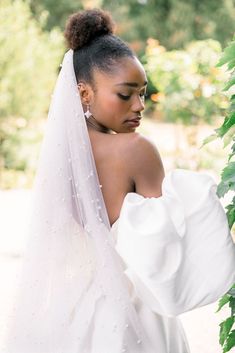 a woman wearing a white wedding dress and holding a green plant in her right hand