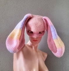 a mannequin head wearing a knitted bunny hat with pastel pink, purple and yellow stripes