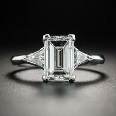 an emerald cut diamond ring with three baguets