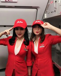 two women in red airline uniforms standing next to each other