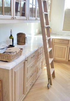 a kitchen with a ladder leaning up against the counter and cabinets in front of it