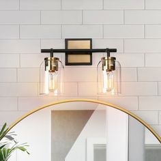 a bathroom light with two lights on the wall above it and a mirror in front of it