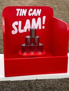 a red sign that says tin can slam on it's stand with some cans in it