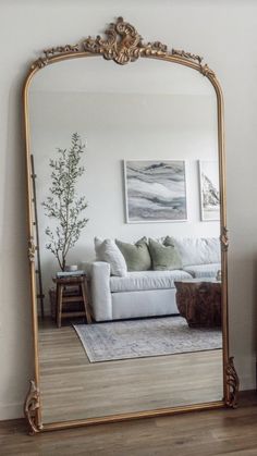 a living room with a large mirror on the wall and a couch in front of it