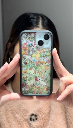 a woman is holding up her phone case