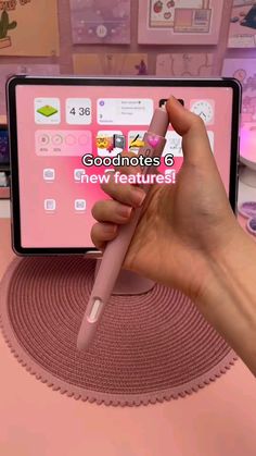 a person holding a pink pen in front of a computer screen with the words goodmotes on it