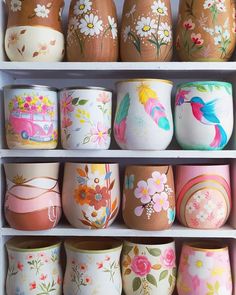 there are many painted pots on the shelves