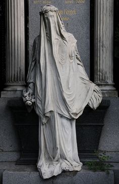 a statue in front of a monument with writing on it