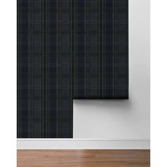 a black and green plaid wallpaper in an empty room with wood flooring next to it