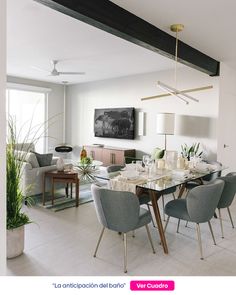 a dining room table and chairs in front of a large window with plants on it