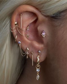 a woman wearing ear piercings with different types of jewelry on her ears and behind the ear