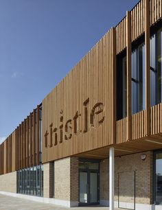 the outside of a building with wooden slats on it's sides and windows