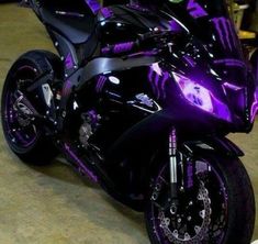 a purple and black motorcycle parked in a garage