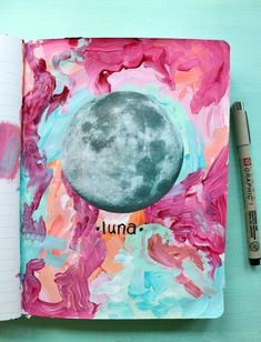 an open notebook with the moon painted on it