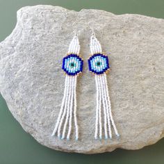 Lucky Eye Tassel Earrings,Blue Eye Fringe Earrings,Minimalist Boho,Protection Jewelry,Dangle Earrings,Long Seed Beaded Earrings Dimensions: Width- 0.8 inches /2cm Length (incl. ear wires)- 4.7 inches /12 cm These adorable earrings are a fun and lovely accessory, perfect for a gift or just for no reason! They are made from OUR ORIGINAL pattern, made from high quality glass beads, very lightweight. *Please note that real colors may slightly differ from their appearance on your display! Ready to Sh White Bohemian Jewelry With Latkans, Bohemian White Jewelry With Latkans, Adjustable Tassel Drop Earrings, White Dangle Jewelry With Tassels, White Tassel Earrings With Latkans As Gift, White Tassel Earrings With Latkans For Gift, Gift Long Drop Tassel Earrings, White Dangle Tassel Earrings As Gift, Handmade White Dangle Plug Earrings