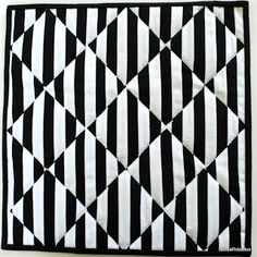 a black and white quilt with an interesting design on the front, featuring diagonals