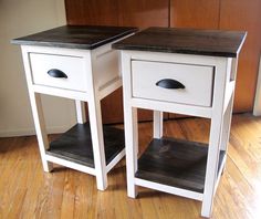 two white nightstands sitting on top of a hard wood floor next to each other