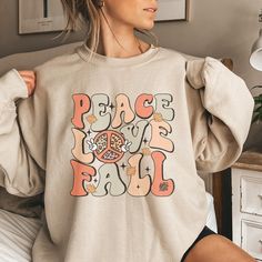 PLEASE NOTE, DUE TO THE BUSY HOLIDAY SEASON ANY ORDERS PLACED AFTER 12/09/24 ARE NOT GUARANTEED TO ARRIVE BY CHRISTMAS.This trendy, retro style Fall Sweatshirt feature the saying Peace, Love, Fall and a cute 70s vibe. Comes in multiple colors! Find more styles here: www.etsy.com/shop/jadeandroseshop ❤️ Please note that for the oversized look you need to buy 1-3 sizes larger than you normally wear. If you prefer the standard Unisex fit order your typical size. For women, if you prefer a more wome Peace Love Fall, Speech Shirts, Football Sweatshirt, Love Fall, Speech Language Pathologists, Trendy Fall, Thanksgiving Shirts, Fall Sweatshirt, Workout Sweatshirt