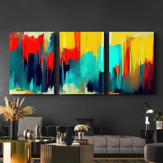 two paintings are hanging on the wall above a couch and coffee table in a modern living room