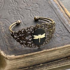 Adjustable dark antiqued brass filigree cuff bracelet with a bee, dragonfly or flower cameo.Cuff is flexible enough to adjust to any wrist.I have matching rings, earrings and necklaces in my shop. Taurus Ring, Bohemian Outfits, Dragonfly Jewelry, Rock Jewelry, Cameo Jewelry, Cameo Ring, Chunky Jewelry, Handmade Wire Jewelry, Wrist Cuffs