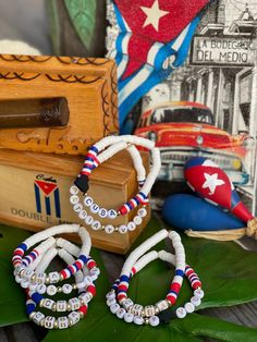 two bracelets with beads are sitting on a table next to a box and other items