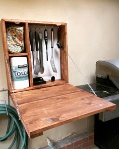 a wooden box with utensils hanging from it's side on a table