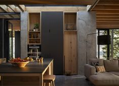 a kitchen and living room are shown in this modern home with large windows overlooking the water