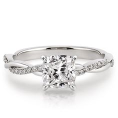 a princess cut diamond ring with twisted shans on the band and side stones set in 18k white gold