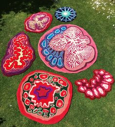 several different colored rugs on the grass