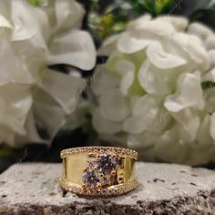 a diamond ring sitting on top of a rock next to some white hydrangeas