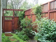 a wooden fence surrounded by lush green plants