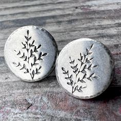 These post earrings are handmade from solid sterling silver.  I have cut a pair of circle discs from a sheet of silver.  I then impressed a sprig leaf into the silver and lightly hammered the borders.  The earrings feature sterling silver posts and sterling silver backings to secure the earrings in place.  The silver has been oxidized and polished to create an antique patina finish. Be sure to see all photos and video for size and finish reference. Circle Size: About 1/2" Total Earring Weight: About 1.4 grams per one earring These sprig leaf earrings make a great gift for a nature lover.  These lightweight studs would be a thoughtful little surprise for someone you love or for a treat to yourself.  Coordinating pieces like those photographed can also be found in my shop. Wise Handmade Jewe Silver Nature-inspired Earrings For Everyday, Silver Everyday Nature-inspired Earrings, Silver Nature-inspired Everyday Earrings, Everyday Silver Nature-inspired Earrings, Sterling Silver Round Birth Flower Earrings, Silver Necklace Designs, Patina Finish, Handmade Jewelry Gift, Gifts For Nature Lovers