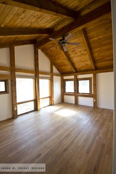 an empty room with wooden floors and ceiling fan