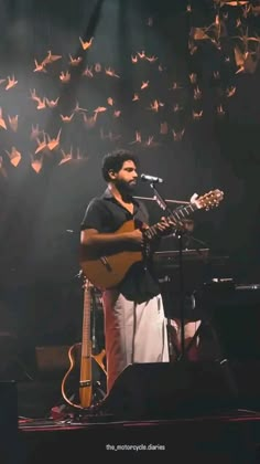 a man playing guitar and singing into a microphone