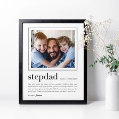 a photo frame with the words stepdad on it next to a vase and flowers