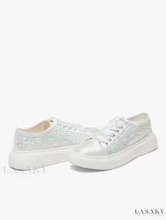 a pair of white shoes with silver sequins on the bottom and one side