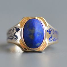 A fabulous antique Art Deco period (1920-1940) sugarloaf lapis lazuli signet ring with cobalt enamel dragons in 14k yellow gold. This wonderful and striking antique ring features a central bezel set oval sugarloaf indigo blue lapis lazuli set north to south in a signet style clipped corner polished gold face that is curved to hug the finger and leads to the most fantastic shoulders with cobalt blue enamel dragons in amazing condition. Ring is hallmarked for 14k gold and engraved "A.C.B. '36". Pl Antique 14k Gold Sapphire Jewelry, Antique Sapphire Jewelry In 14k Gold, Blue Art Deco Jewelry Stamped 14k, Antique Blue Jewelry For Ceremonial Occasions, Vintage Oval Lapis Lazuli Jewelry, Vintage Lapis Lazuli Round Jewelry, Vintage Lapis Lazuli Oval Jewelry, Blue Antique Signet Ring For Formal Occasions, Vintage Lapis Lazuli Gemstone Jewelry