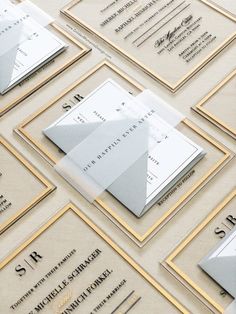 luxury acrylic envelopes and business cards are displayed on a table with gold trimming