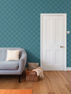 a blue couch sitting in front of a white door next to a chair and rug