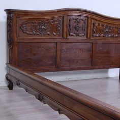 a wooden bed frame with carved carvings on the headboard